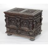 A 17th Century style oak chest, the hinged cover with two armorial carved panels,