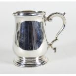 A silver mug, HA, Sheffield 1918, of baluster shape with leaf capped scroll handle,