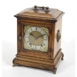 An Edwardian mantel clock in a rosewood case with lion masks to the sides and handle to the top,