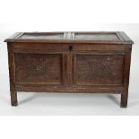 An 18th Century and later oak coffer with hinged panel top and stylised floral carving to the front,