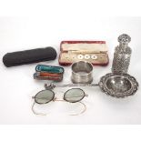 A Chinese white metal strainer, a silver napkin ring, a white metal bottle and cover,