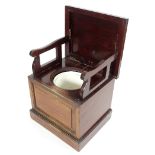 A Victorian mahogany box commode, the hinged cover enclosing arm rests,
