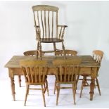 A pine farmhouse dining table with five pine dining chairs and a pine armchair,