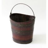 A brass bound oval coal pail with swing handle,