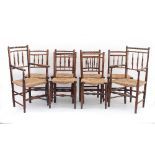 A set of eight spindle back rush seat dining chairs with bobbin turned top rails on turned legs and