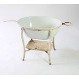 A baby's oval white enamel bath with wrought iron stand,
