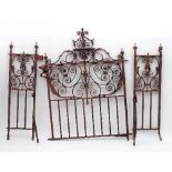 A wrought iron garden gate with scrollwork decoration and two separate side panels,