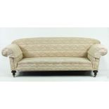 A Victorian sofa on turned mahogany legs with brass castors,