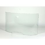 A curved glass fire guard by Pierre Frey, with pierced carry handle,