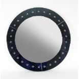 A very large circular mirror with bevelled glass frame and black mirrored glass set with convex