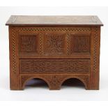 An Arts and Crafts oak mule chest of small proportions,