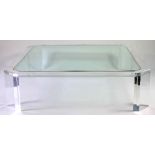 A large Lucite and glass coffee table, the inset glass top with canted corners,