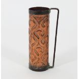 An Arts & Crafts copper wine bottle carrier of cylindrical form with embossed wave and scroll