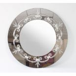 A large circular mirror, the mirrored surround decorated with clear glass fleur-de-lis and scrolls,