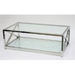 A stainless steel and glass topped low table with X support to each end within a frame,