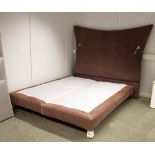 A six foot bed on silvered hairy paw feet together with a large brown leather upholstered headboard