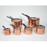 A closely matched graduated set of six copper saucepans with covers