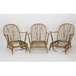 Three Ercol low Windsor type beech armchairs, each with deep seats and spindle backs,