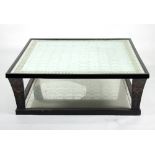 A large square modern coffee table with silvered and verre églomisé top on ebonised mirror panelled