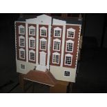 A large hand built dolls house with an assortment of furniture.