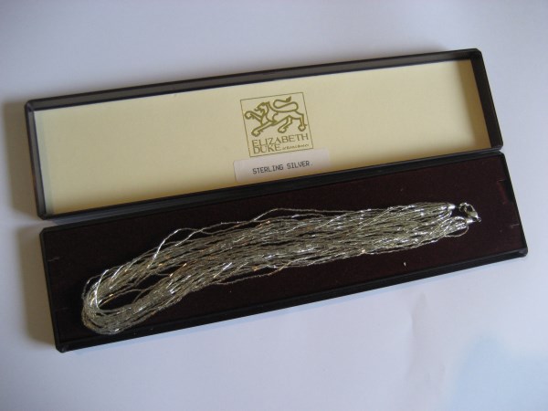 An Elizabeth Duke of Bond Street silver necklace in fitted case.