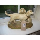 A Royal Dux figure group of two setter dogs, one seated, the other standing on a naturalistic