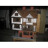 A large hand built dolls house with an assortment of furniture.