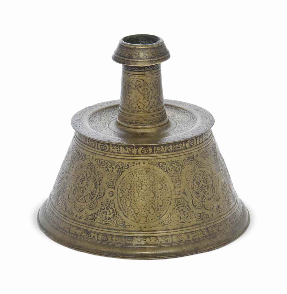 AN ENGRAVED COPPER-ALLOY CANDLESTICK ILKHANID IRAN, 13TH CENTURY Of typical form, the engraved