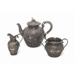 A SILVER-REPOUSSÉ THREE-PIECE TEA SET MARKED OOMERSI MAWJI, KUTCH, NORTHWEST INDIA, LATE 19TH