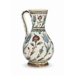 AN IZNIK POTTERY JUG OTTOMAN TURKEY, CIRCA 1620 Of baluster form on short foot with simple handle