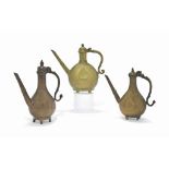 THREE MUGHAL COPPER-ALLOY EWERS NORTH INDIA, 18TH CENTURY Each with drop-shaped body on four feet,