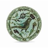 A FIGURAL IZNIK POTTERY DISH OTTOMAN TURKEY, 17TH CENTURY On short foot, of shallow form, the