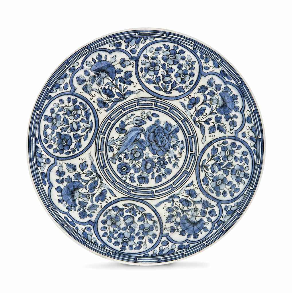 A BLUE AND WHITE POTTERY DISH QAJAR IRAN, 19TH CENTURY On short straight foot, of shallow form,