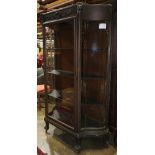 Arts and Crafts oak display cabinet, with carved lionheads and central shell cornice, fitted with