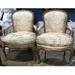 Pair of Louis XV style fauteuils, each having a floral decorated crest, above the gold down