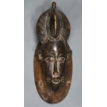 Guro, Cote d’Ivoire mask, having an elaborate coiffure, above stylized facial features and