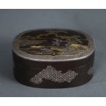 Japanese damascene zogan oval lidded box, gilt/silver on iron, the lid decorated with scenery of