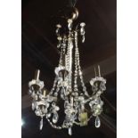 Continental six arm crystal chandelier, having crystal swags cascading to the six arms, each with