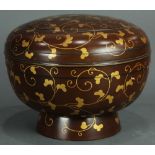 Japanese lacquered circular container, decorated with karakusa in gilt on a brown ground, having a