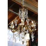 Continental six light chandelier, having a baluster standard centered with the patinated support