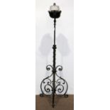 Spanish Revival style patinated metal torchiere, having a single light with glass reservoir, above a