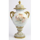 Continental porcelain urn, having a Classical form with stylized handles and gilt accents