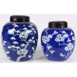 (lot of 2) Chinese underglaze blue lidded jars, ovoid body with prunus flowers against a cracked-ice