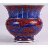 Chinese porcelain zhadou, with underglaze blue dragons chasing a flaming pearl over a red ground,