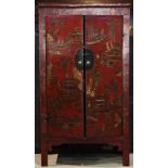 Chinese red lacquered wooden cabinet, hinged double doors decorated with a gilt pavilion complex