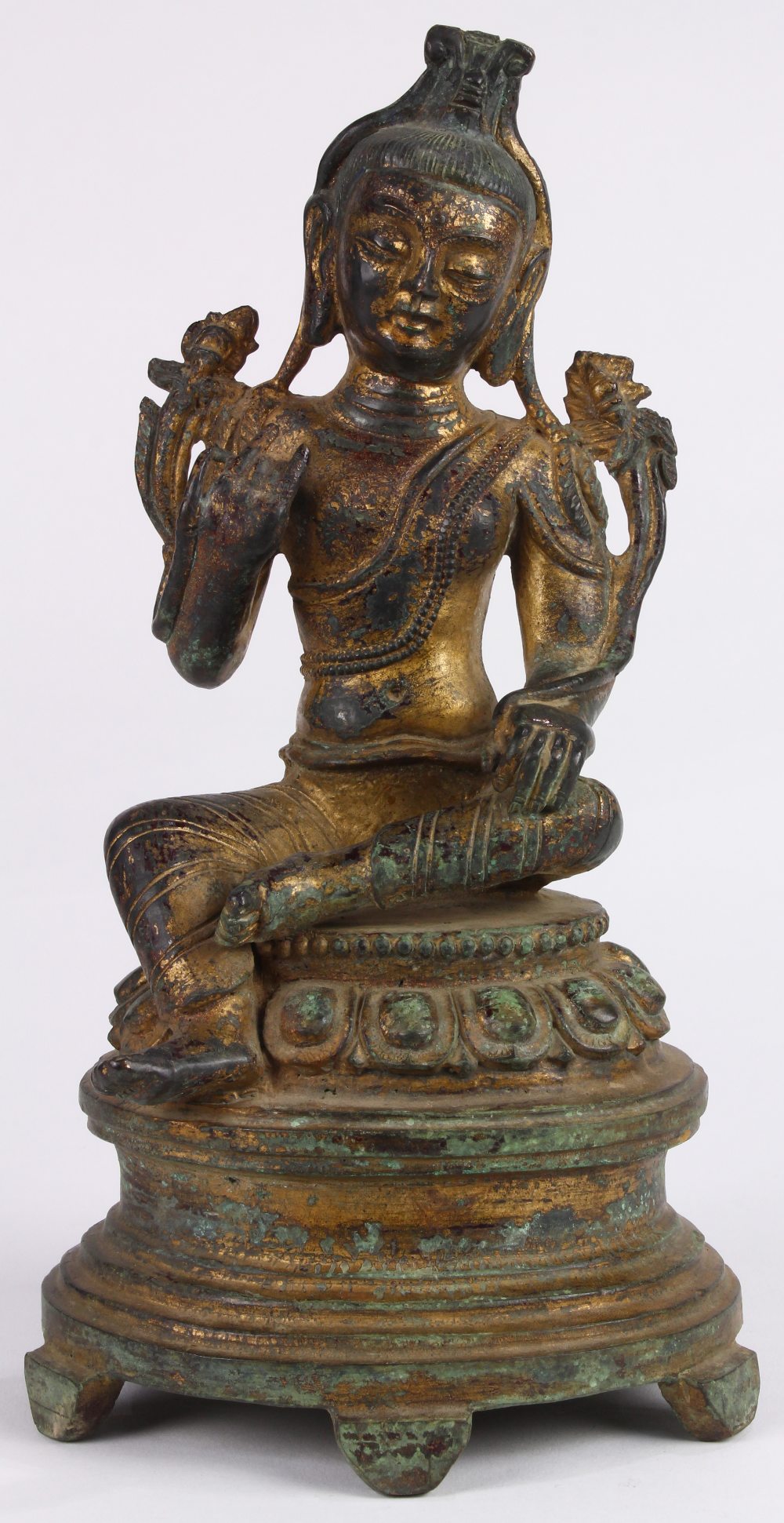 Chinese gilt bronze bodhisattva, seated in royal ease on a lotus pedestal, holding two lotus sprigs,