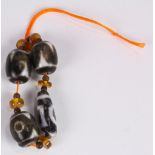Strand of four tianzhu/dzi type beads, with one slender and three drum form beads with various