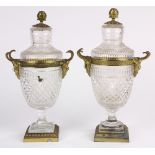 Pair of Neoclassical style cut glass and ormolu lidded urns, the baluster form flanked by mystical