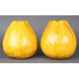 (lot of 2) Chinese glazed ceramic pomelos, coated with a dark yellow glaze and having an aperture on