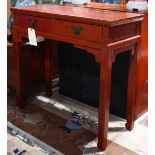 Chinese red lacquered table, fronted by two drawers with butterfly form fittings and shaped pulls,